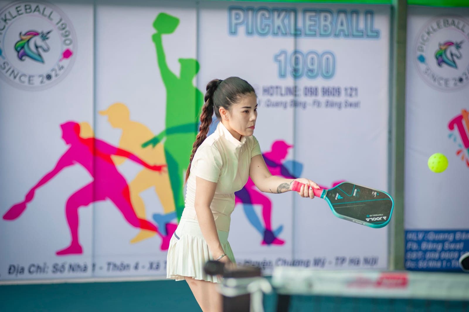A pickleball rally in progress on an outdoor court